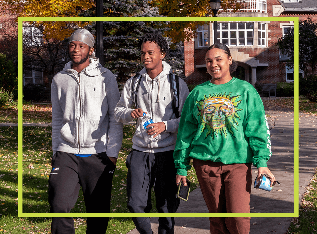 Three students walking outside on campus.